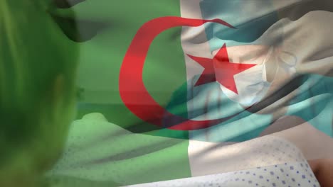 animation of flag of algeria over caucasian surgeons with face masks during surgery