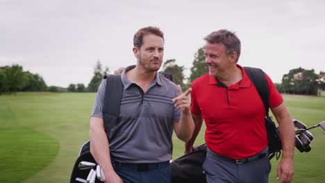 dos parejas maduras jugando al golf caminando por el fairway llevando una bolsa de golf