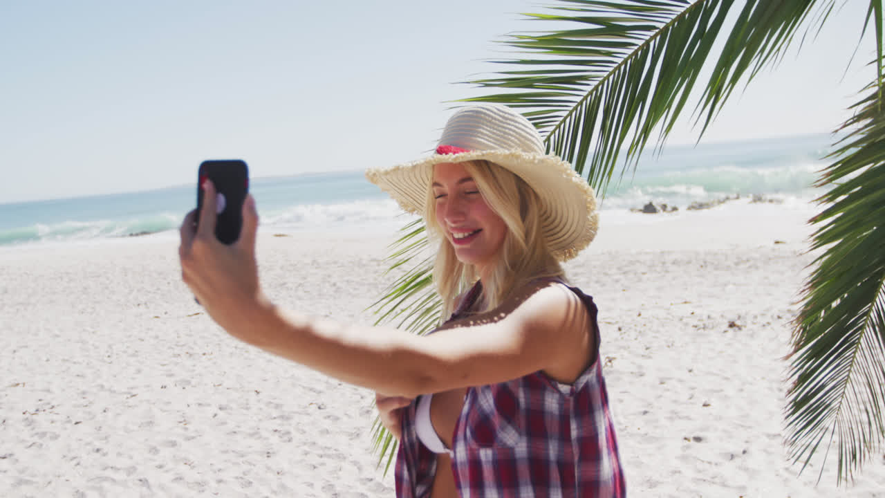 retrato de una mujer caucásica tomando una selfie en la playa