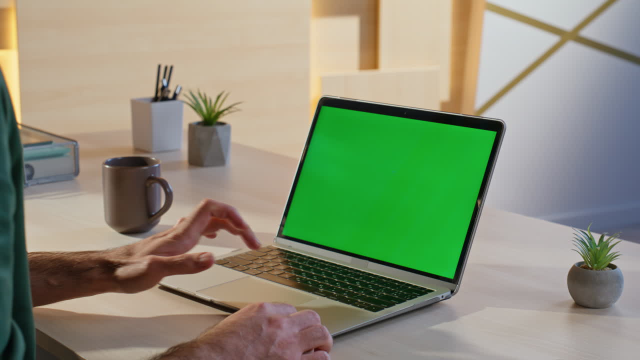 portátil con pantalla verde en el escritorio