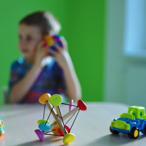 toys on table. bright toys on blur background of preschooler boy. happy childhood. little boy having fun with toys.