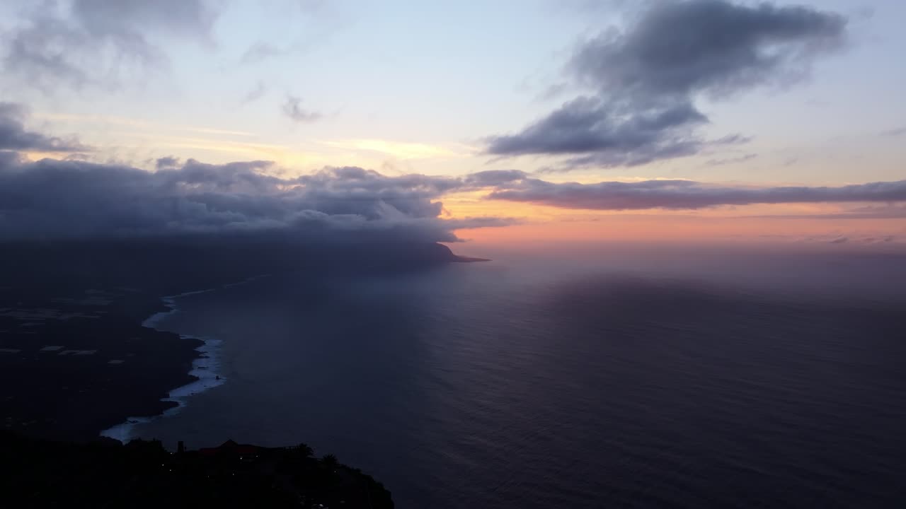 Sun dips behind dark clouds, La Frontera valley seen from cliffs near Guarazoca