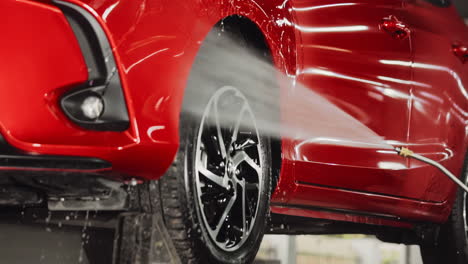 close-up footage of a high-pressure water jet forcefully penetrating the interior of a car's front fender