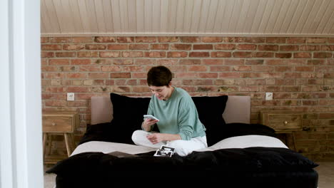 woman using phone on bed