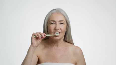 senior woman brushing her teeth