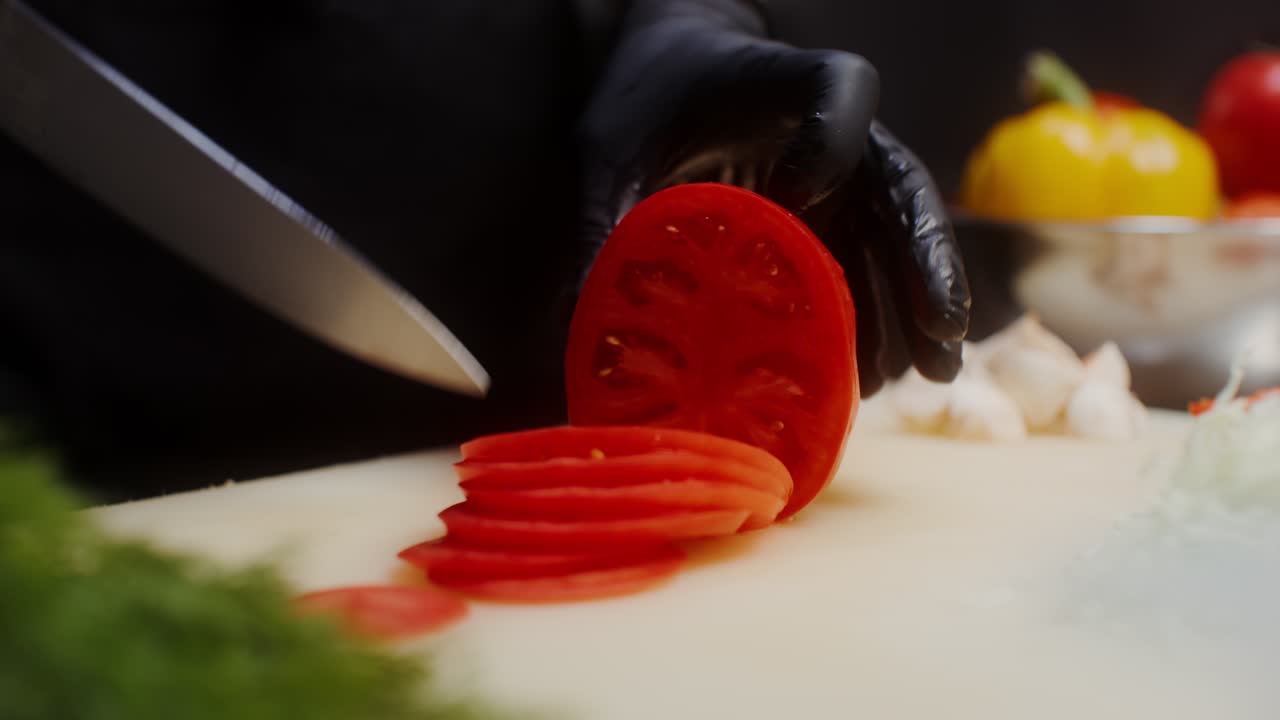 셰프가 토마토를 잘라내고 있습니다.