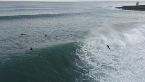 toma épica en cámara lenta de un surfista montando una ola en el agua fría de islandia, aérea