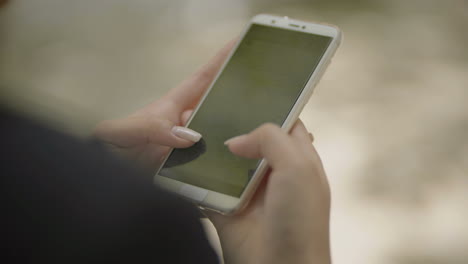 fotografía recortada de una mujer usando un teléfono móvil