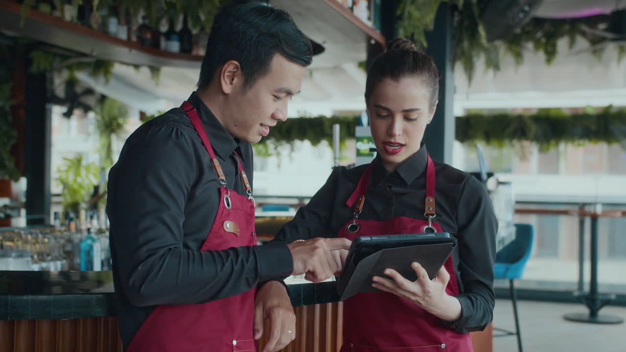 Waitress Instructing Newcomer at Restaurant