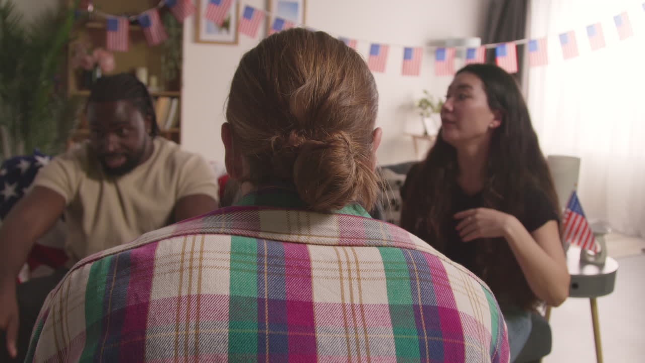 집에서 친구들과 함께 미국 독립의 날인 7월 4일을 축하하고 술을 마시며 이야기하고 있습니다.