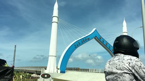 남성, 몰디브에서 다리를 건너기 위해 기다리는 오토바이 라이더