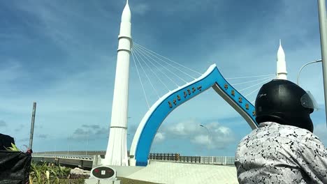 motorbike rider waiting to cross a bridge in male, maldives