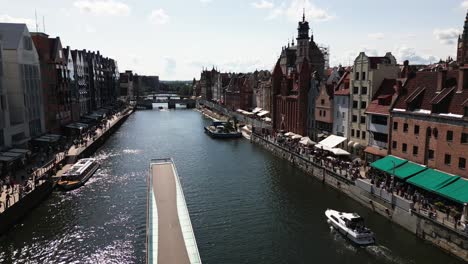 flying-over-the-motlawa-in-the-big-city-gdansk,-river-through-the-city-centre-with-ships,-danzig,-gdansk,-poland,-europe,-drone