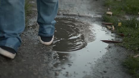 Schlammige-Pfütze,-Die-Den-Weg-Reflektiert,-Wenn-Füße-Vorbeigehen