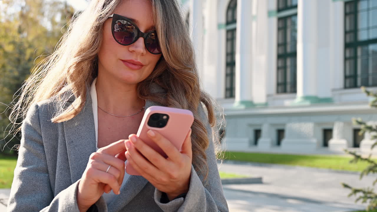 Donna bruna che scorre contenuti sul telefono in una terrazza