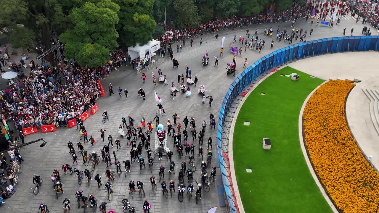 Aerial shot of a contingent of bicycles and non-motorized vehicles with a skeleton Mojiganga during their participation in the Day of the Dead festival on Paseo de la Reforma in Mexico City