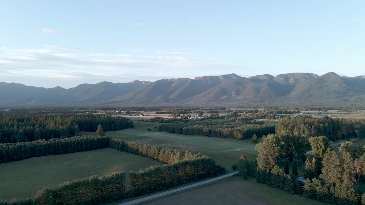 背景に山々が連なるモンタナの野原をパンするドローン - 空撮