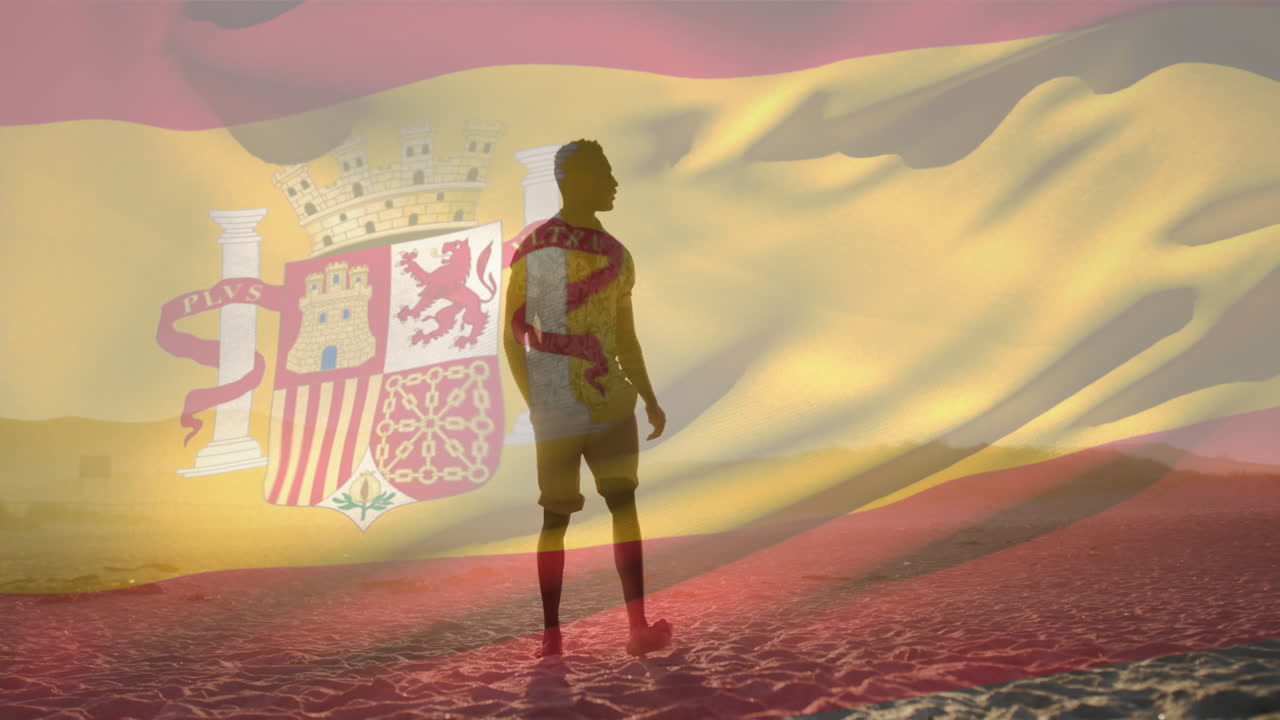 video compuesto de agitar la bandera de españa contra un hombre afroamericano caminando en la playa