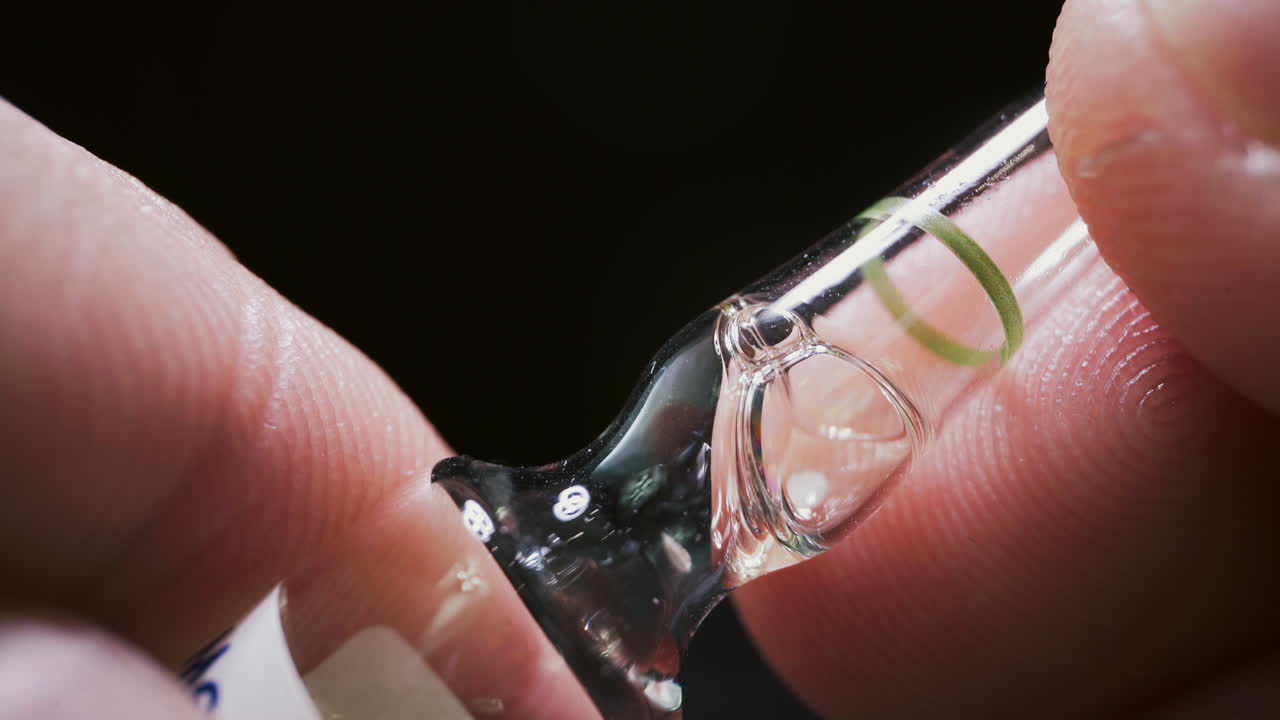 persona sostiene una ampolla con muestra de vacuna antiviral en los dedos