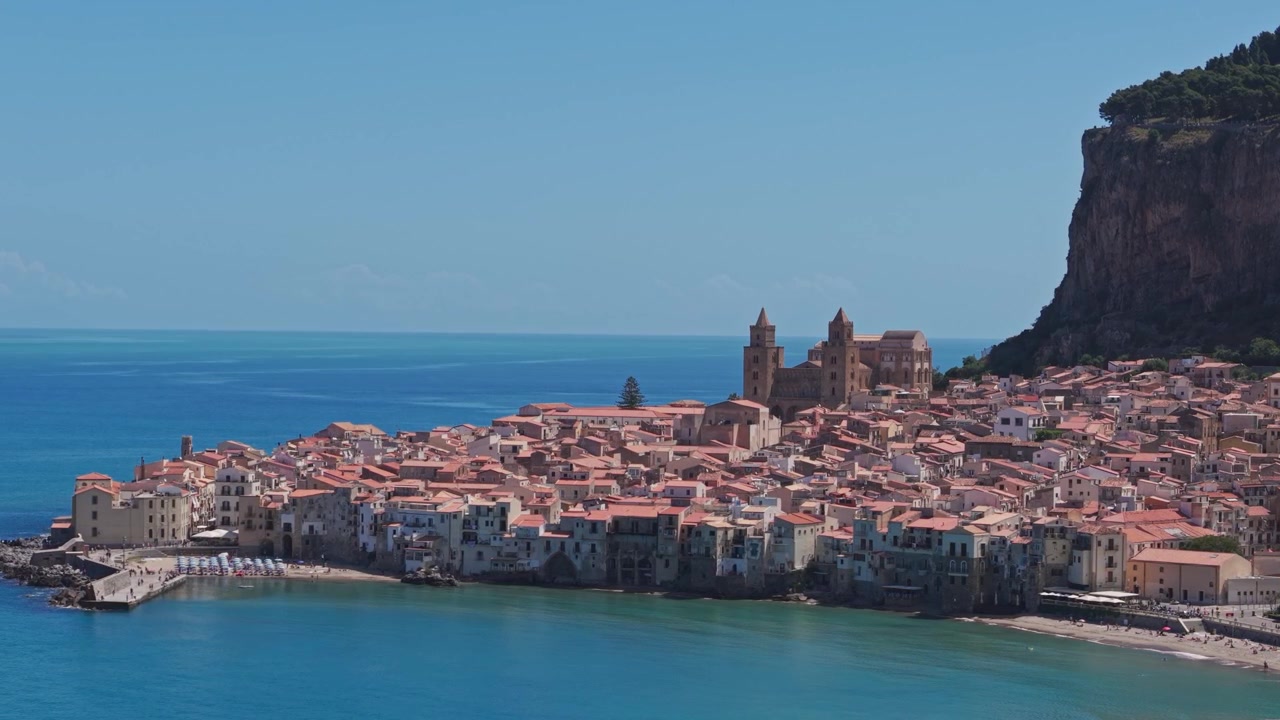 Storica città costiera con cattedrale e mare Mediterraneo turchese.
