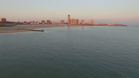 aerial: the boulevard, beach and city of vlissingen during sunset