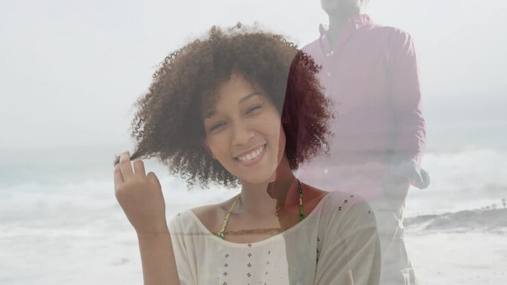Uomo che cammina lungo la riva, con un'animazione sovrapposta di una donna sorridente in spiaggia.