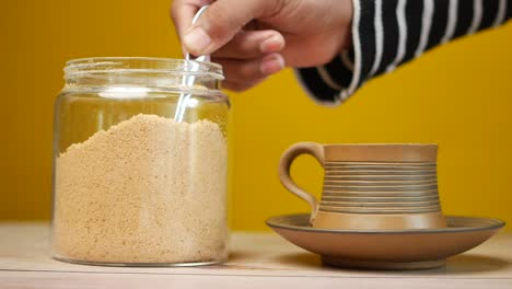 pouring brown sugar into coffee cup