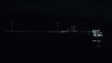 Night-view-of-a-Victorian-pier-with-an-illuminated-ferry-boat,-a-peaceful-and-nostalgic-scene