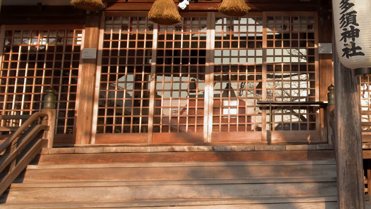 日本神道教神社的靜態中景鏡頭，懸掛著紙燈籠和注連繩。