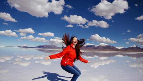 woman jumping with joy on a mirrored salt flat