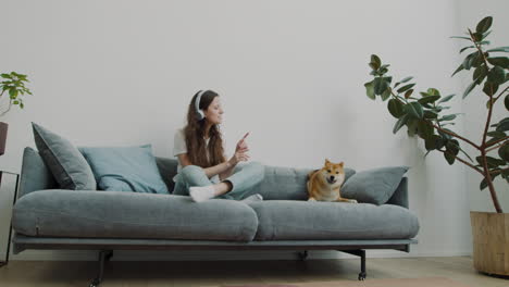 girl plays with her dog on the sofa