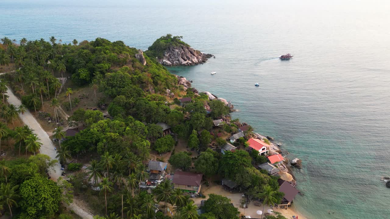 Drone flying forward over beautiful tropical island at sunset