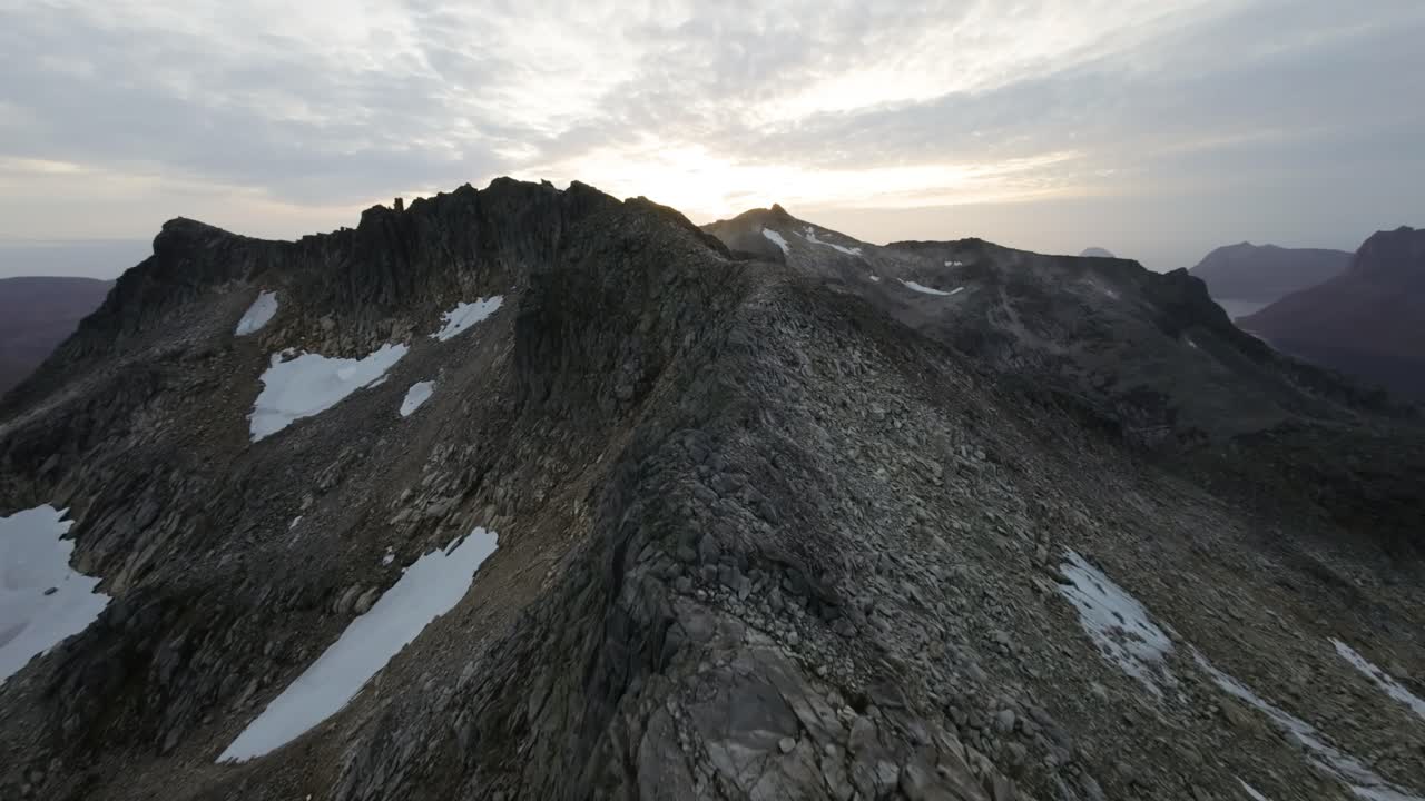 Volo radente lungo una cresta montuosa durante il tramonto nella Norvegia settentrionale