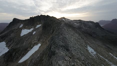 volando a lo largo de una cresta montañosa durante la puesta de sol en el norte de noruega