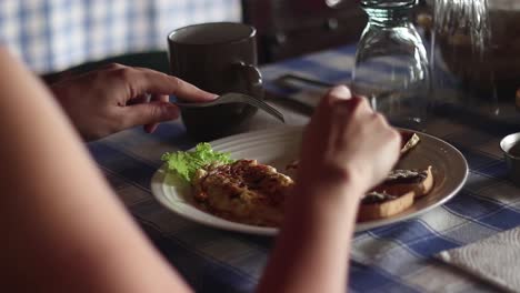 close up of a tourist eating a dish with cheese, bread and chicken in little restaurant