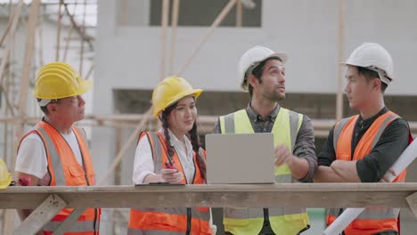equipo de contratistas profesionales multirraciales está trabajando en el sitio de construcción de viviendas. arquitecto masculino caucásico o ingeniero civil hablando con el capataz sobre el progreso de la construcción de la casa del proyecto de vivienda.