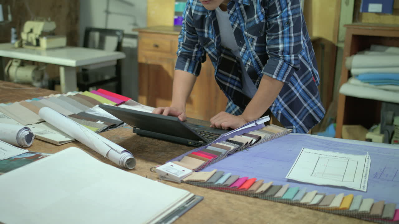 arquitecto ocupado trabajando en su computadora portátil y revisando algunos diseños