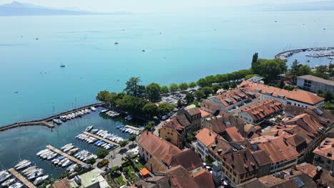 drone reveal of the old city of lutry with the lake of geneva and the alps behind