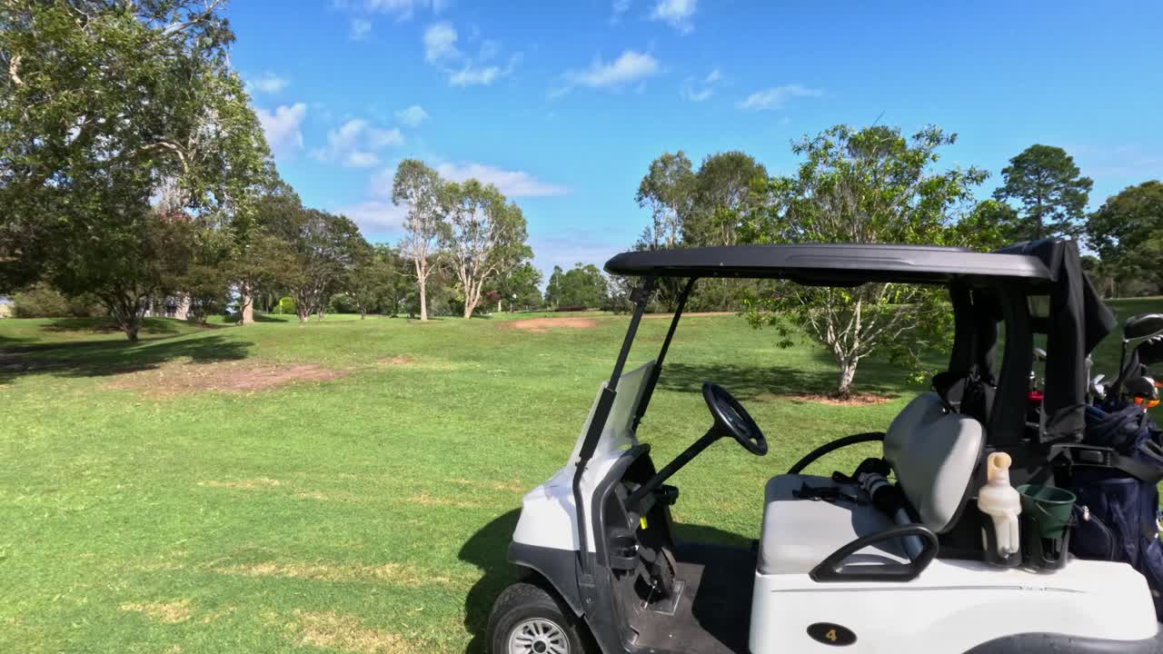 晴れたゴルフコースを通って動くゴルフカート