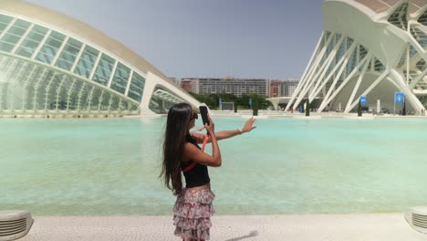 woman taking photos in front of the city of arts and sciences