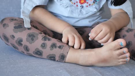 child sitting with painted toes