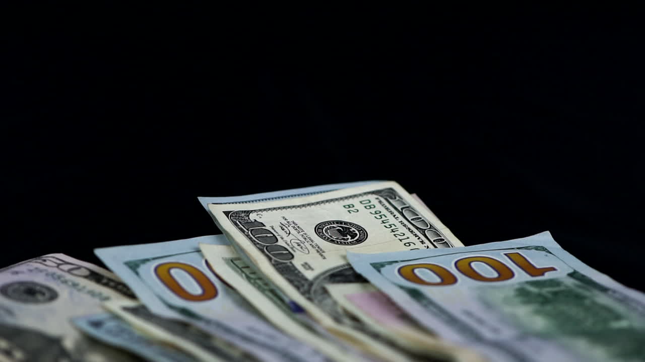 Money Bills In Various Currencies Drop Against Black Background - close up, studio shot