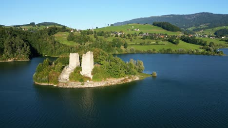 push in drone shot of ogoz island and the lake of gruyere in the canton of fribourg in switzerland