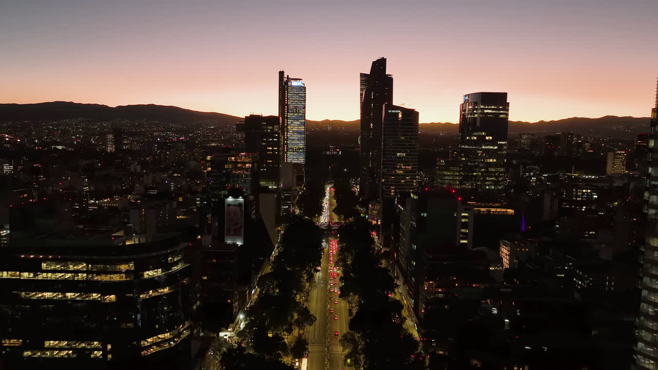 Aerial view over the illuminated Reforma avenue, colorful dusk in Mexico city