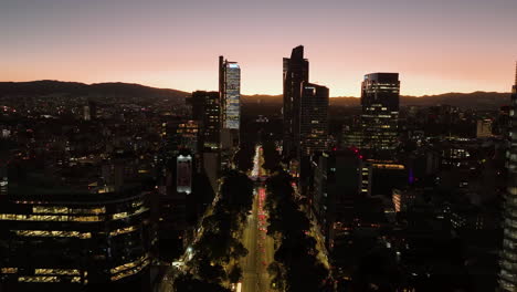 aerial view over the illuminated reforma avenue, colorful dusk in mexico city