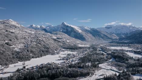 the giffre valley, showcasing snow-covered mountains and a quiet town, aerial view