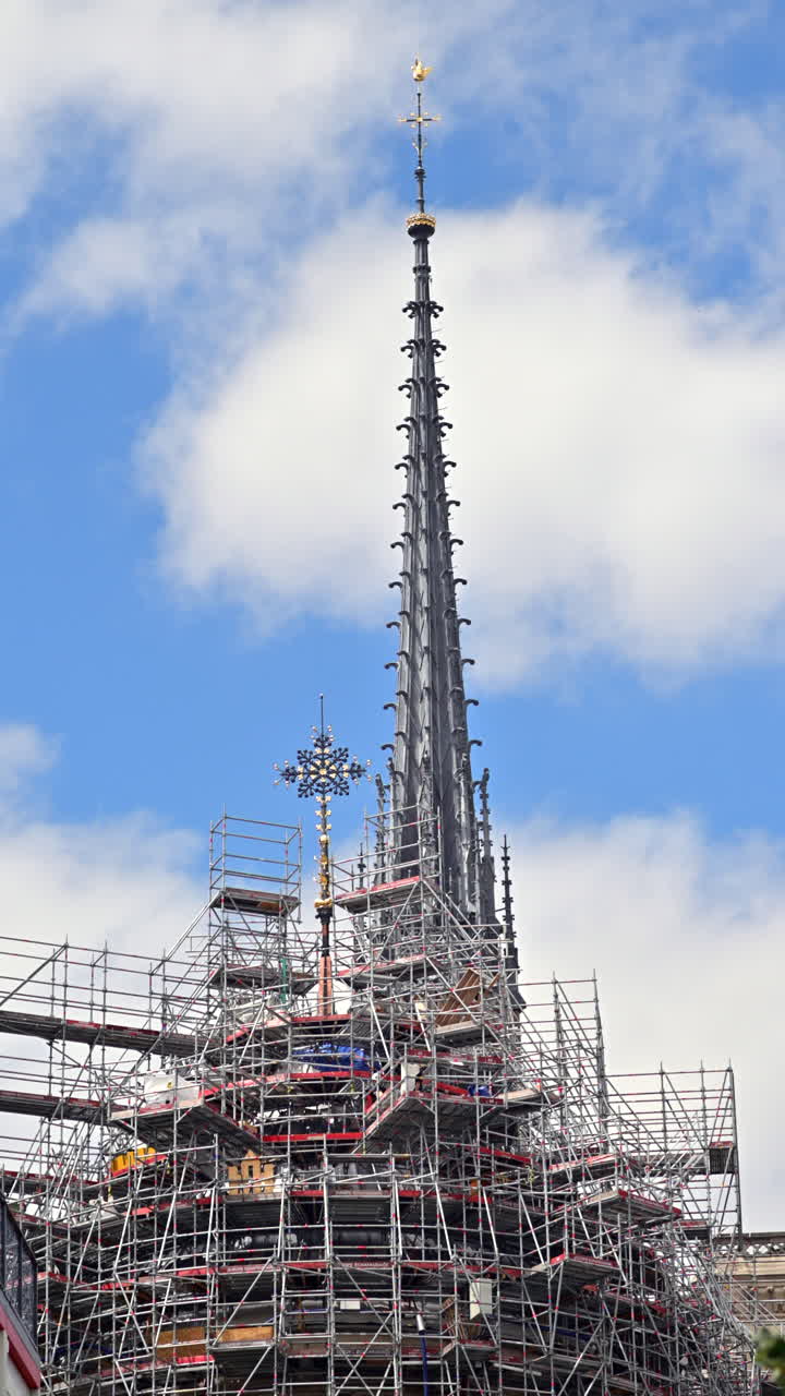 The Notre-Dame Cathedral in Paris, France under reconstruction with the blue sky on the background. Vertical