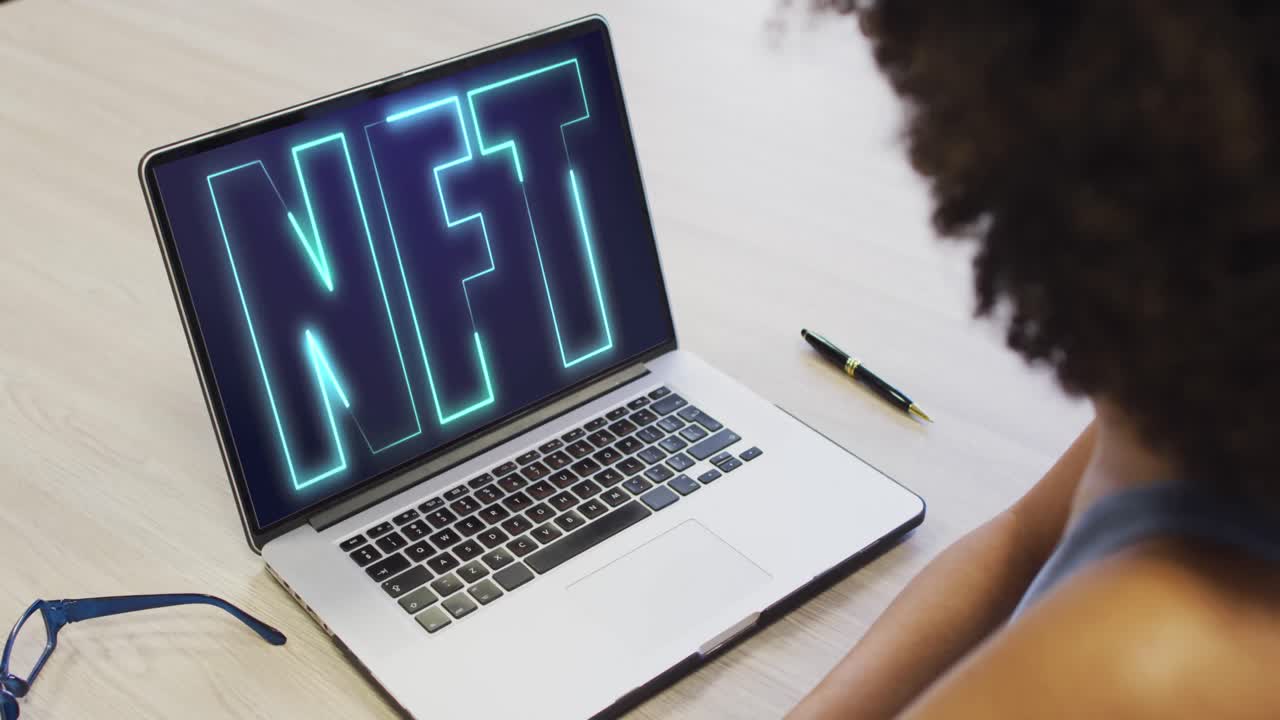 African american businesswoman using laptop for video call with nft text