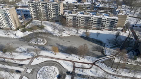 Aerial-dolly-of-people-skating-on-frozen-pond-in-a-small-Dutch-city-in-the-Netherlands