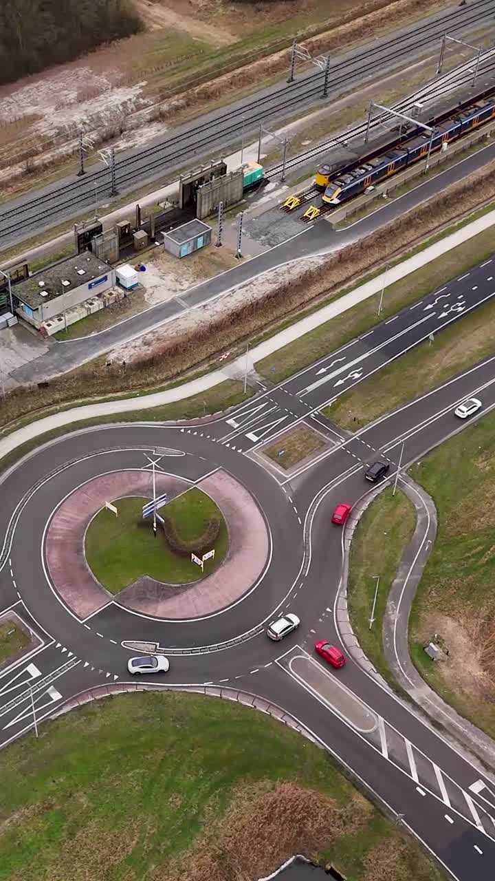 Aerial view of a roundabout with cars and a train